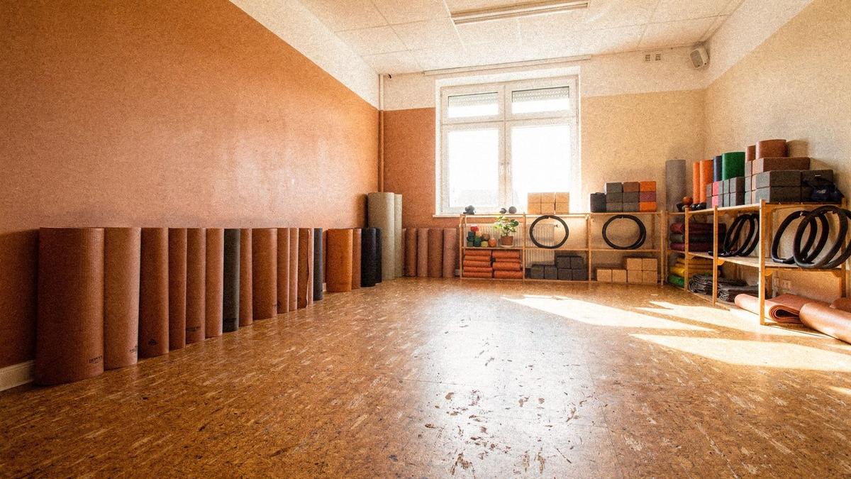 Mats, blocks and straps set out in a bright beginner studio room